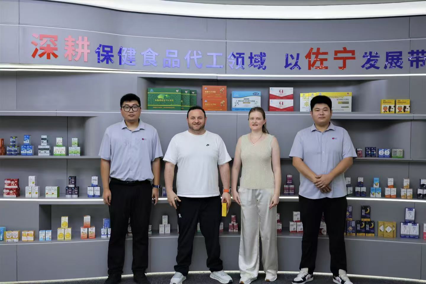 Client and Zuoning team in the showroom in front of product display wall