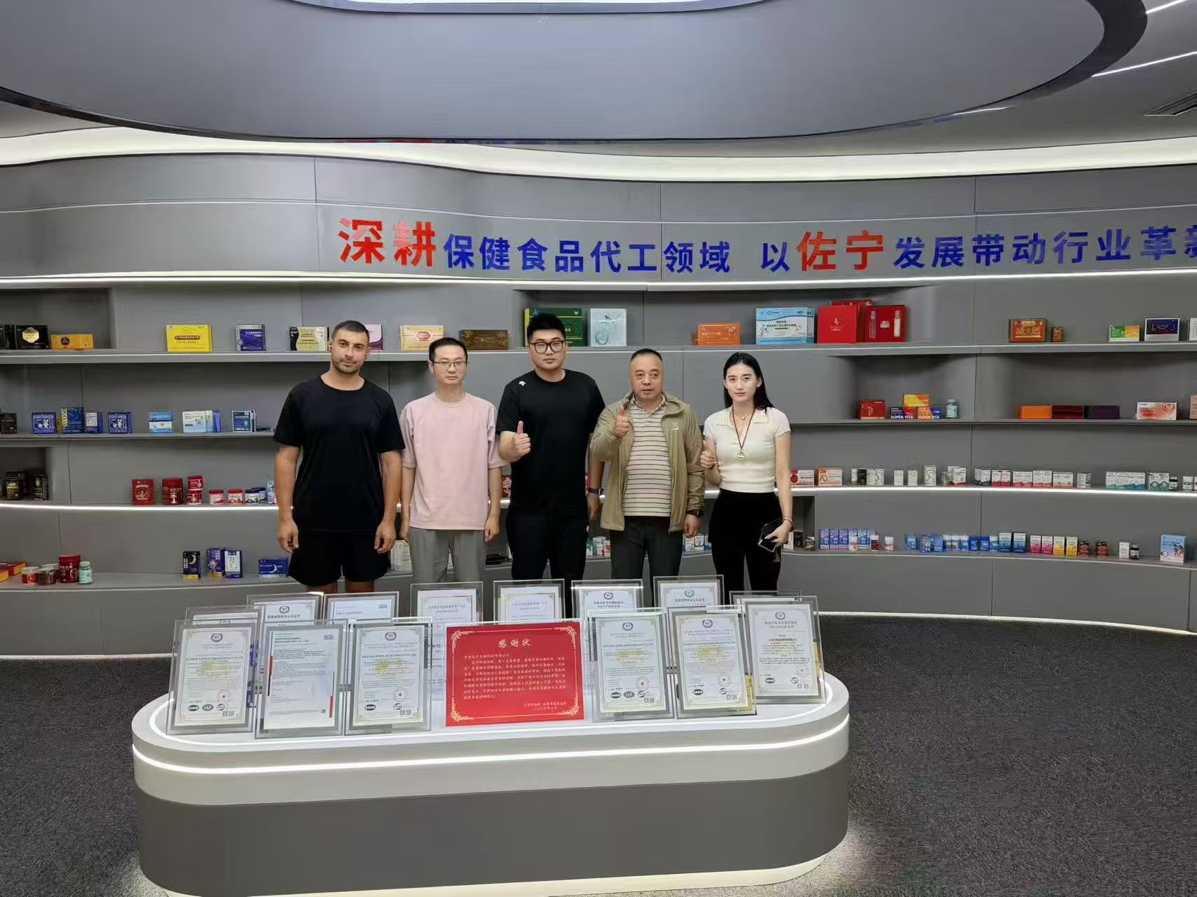Zuoning team with certificates, licenses, and product display